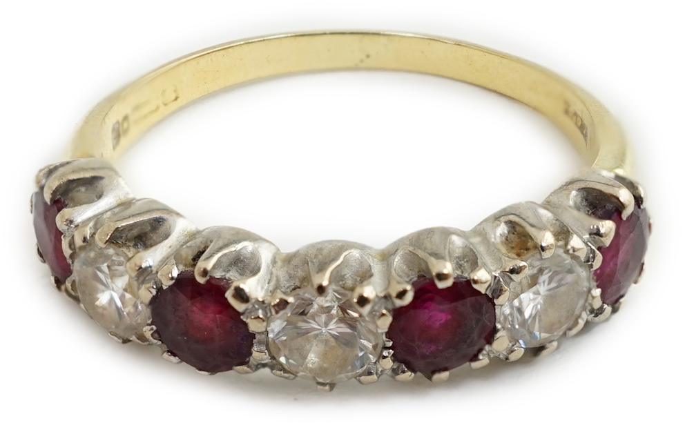 An 18ct yellow and white gold three stone diamond and four stone ruby set half hoop ring